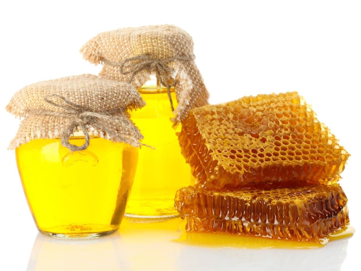 Вкушая вкусих мало меда. Соты меда. Пчелиные соты с медом. Мед на белом фоне. Мед в сотах на белом фоне.